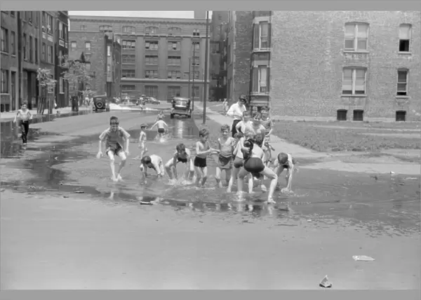 CHICAGO: SUMMER, 1941. Children cooling off from the summer heat in water