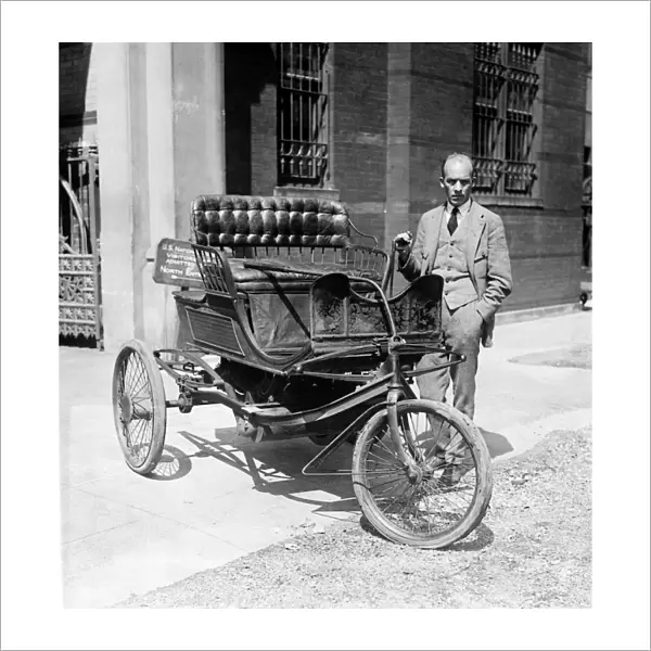 THREE-WHEEL AUTOMOBILE. Carl W. Mitman, curator of engineering at the Smithsonian Institution photographed with a 1909 three-wheel automobile, which won first prize in a New York parade as the oldest vehicle running on its own power, 6 September 1924