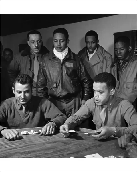 WWII: TUSKEGEE AIRMEN, 1945. Group of Tuskegee Airmen playing cards in the officers club at Ramitelli Airfield, Italy. Photograph by Toni Frissell, March 1945. Seated: Robert Spurlock (left) and Harold Morris. Standing, left to right: Conrad Johnson, Ronald Reeves, Leroy Roberts, and Calvin Spann