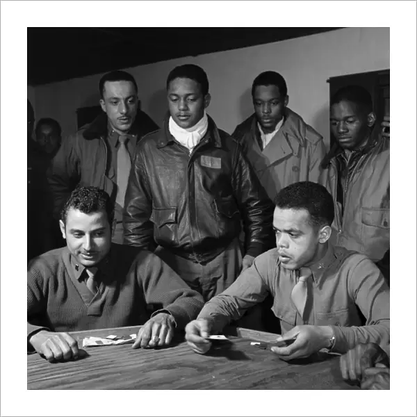 WWII: TUSKEGEE AIRMEN, 1945. Group of Tuskegee Airmen playing cards in the officers club at Ramitelli Airfield, Italy. Photograph by Toni Frissell, March 1945. Seated: Robert Spurlock (left) and Harold Morris. Standing, left to right: Conrad Johnson, Ronald Reeves, Leroy Roberts, and Calvin Spann