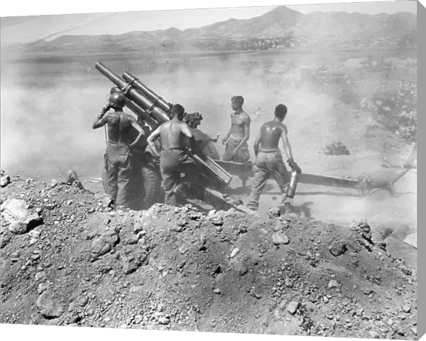 KOREAN WAR: ARTILLERY. U. S. artillerymen firing a 105mm howitzer on North Korean positions near Uirson, South Korea, August 1950