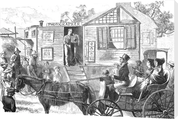 ITINERANT PHOTOGRAPHER. Photographing a party in their carriage at a small American town. Wood engraving after Thomas Worth, 1871