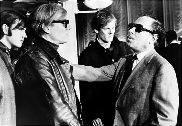WARHOL AND WILLIAMS, 1967. American artist and filmmaker Andy Warhol (left) speaking with American playwright Tennessee Williams aboard the S. S. France, 1967. Photographed by James Kavallines