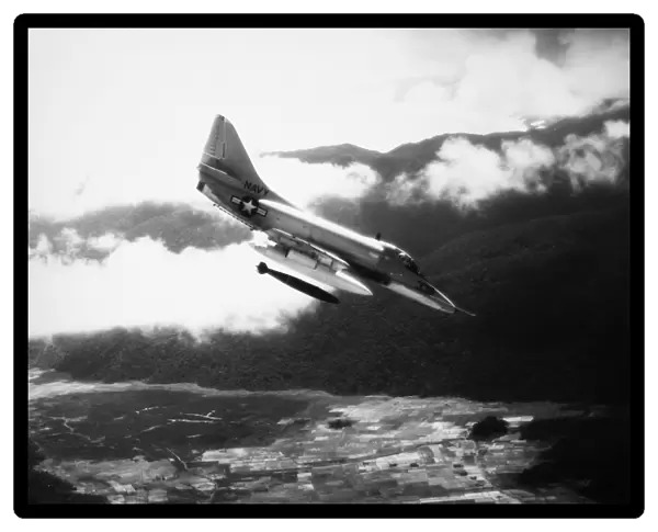 A U. S. Navy A4 Skyhawk dropping a bomb on Viet Cong forces in South Vietnam, 1965