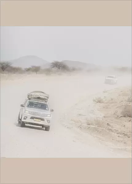Cars on a dusty desert road in Namibia