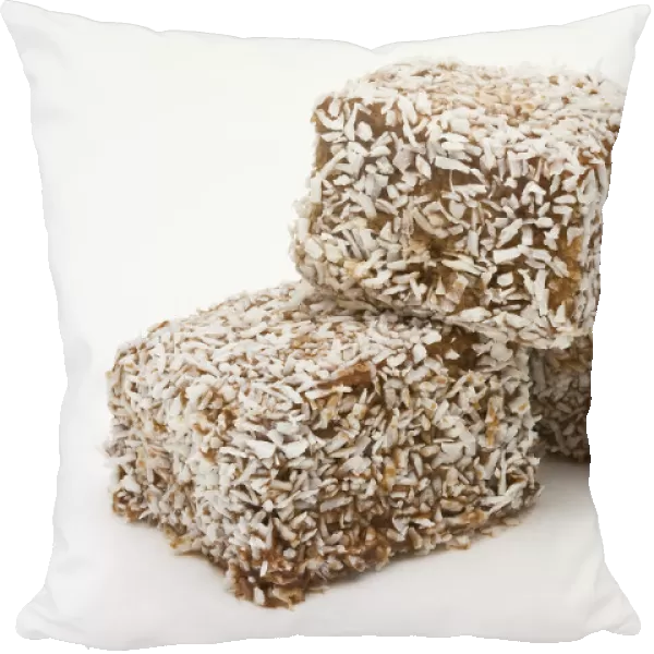 Three Lamington sponge cakes covered with cococnut