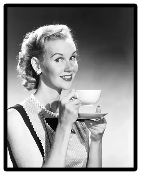 Housewife in pearls and apron drinks coffee