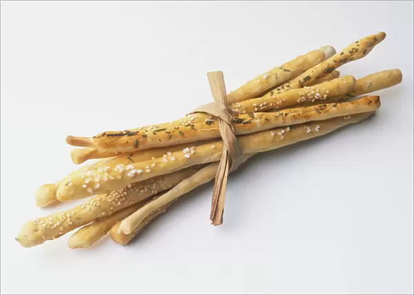 Grissini Torinesi topped with fresh rosemary, coarse sea salt and sesame seeds, tied together using a reed