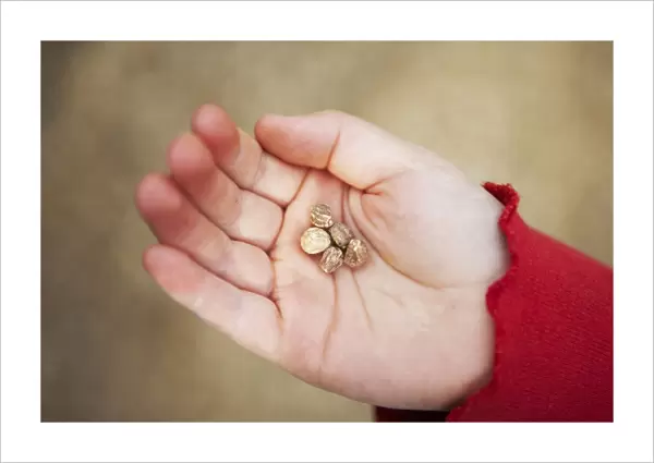 Girl with five nasturtium seeds in palm of hand, close-up