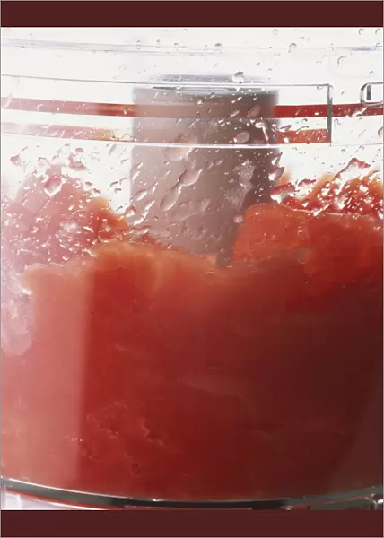 Tomatoes being pureed in a food processor, close up