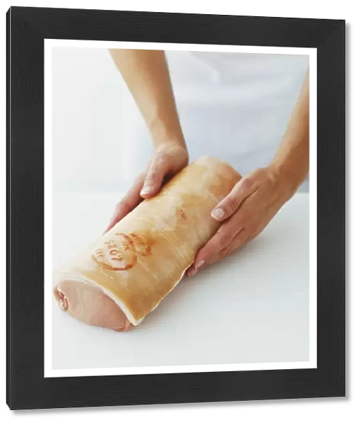 Using hands to form boned pork loin into sausage shape