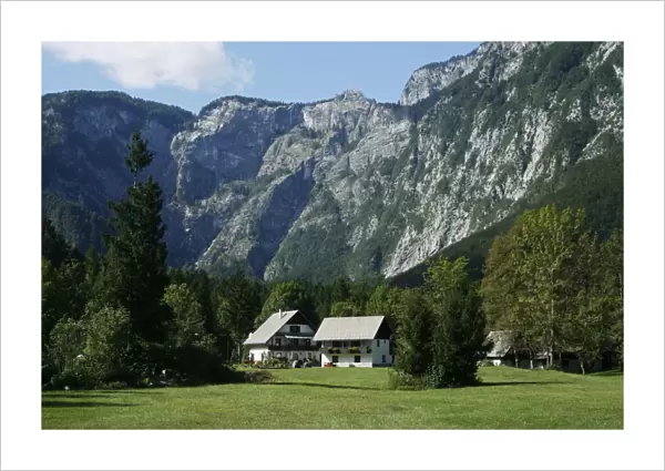 Slovenia, Bohinj, Ukanc, alpine farmhouses in village below mountains