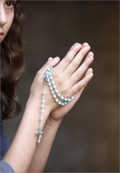 Girl praying with prayer beads