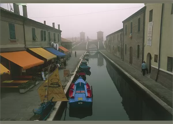 Italy, Emilia-Romagna Region, Comacchio (Ferrara Province), Po Delta Regional Park, Coloured batana boats along canal