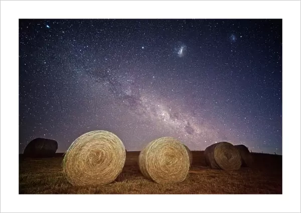 Milky way and magellanic clouds over hay bales