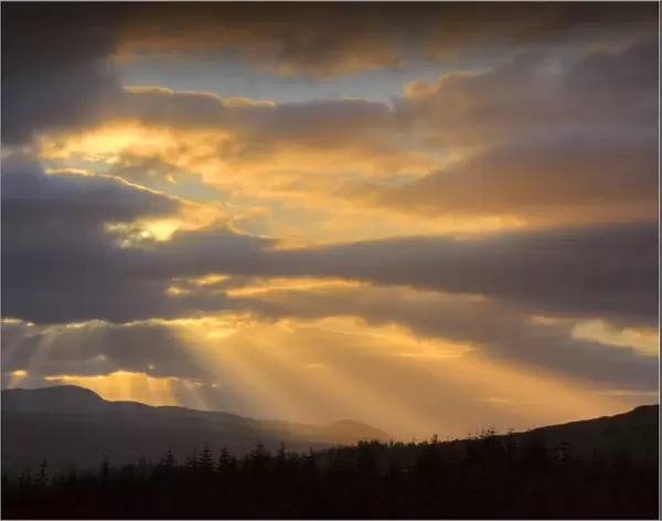 Dawn rays light up the sky over Loch Duich in the highlands of Scotland