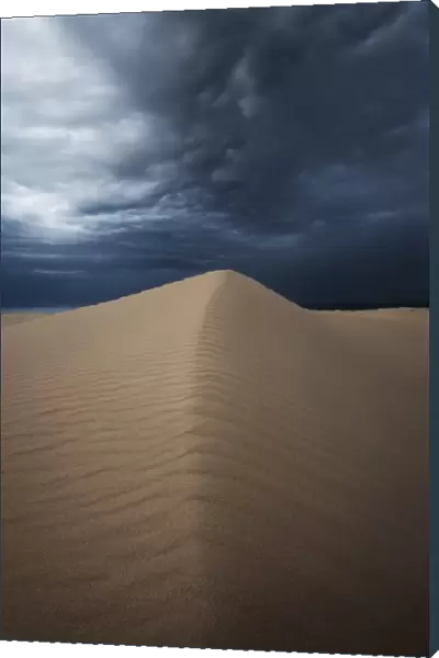 Sand dunes with storm clouds