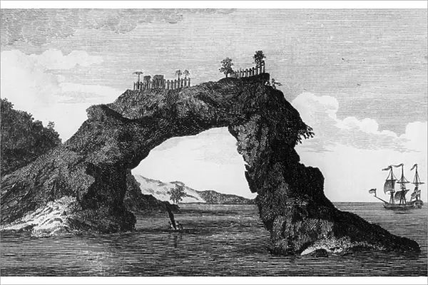 Rock Arch. An arched rock topped with a fenced compound on the coast of New Zealand