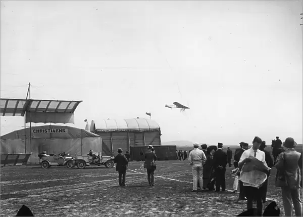 In Flight. July 1910: Planes flying over the hangars at a Bournemouth Aviation meeting