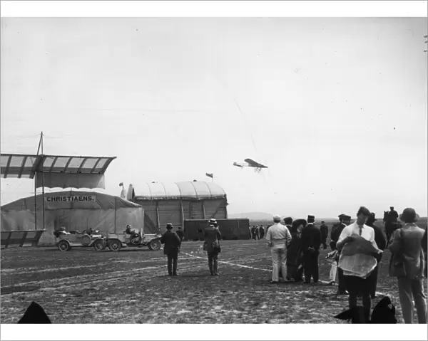 In Flight. July 1910: Planes flying over the hangars at a Bournemouth Aviation meeting