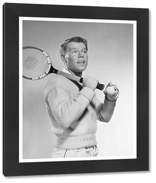 Man holding tennis racket over his shoulder