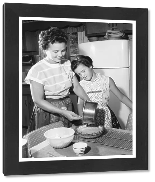 Mother and daughter making pie