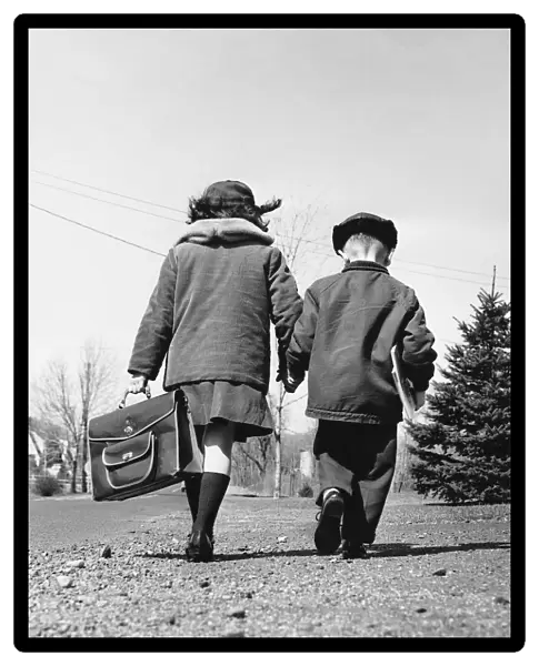 Boy and girl holding hands, walking to school