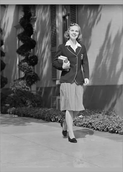 Female student walking outside school, portrait