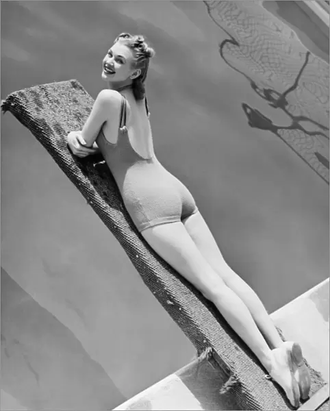 Woman lying on diving board (B&W), elevated view, portrait