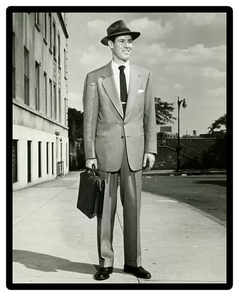 Man in full suit standing on sidewalk, (B&W), (Portrait)