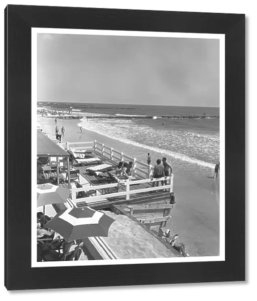 People relaxing on beach, (B&W), elevated view