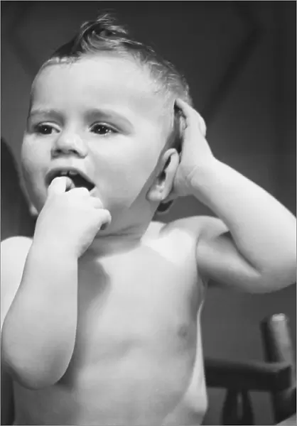 Baby boy (9-12 months) with finger in mouth (B&W)