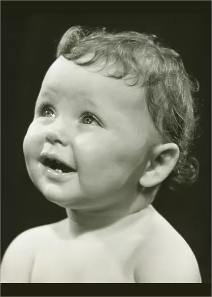 Baby boy (12-18 months) looking upwards, (B&W), close-up