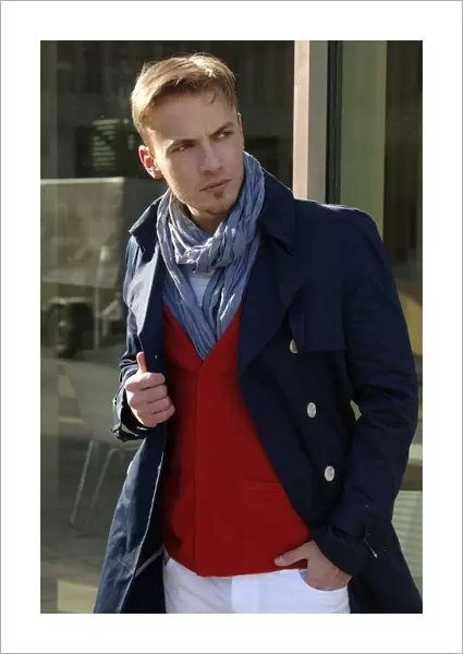 Fashion image, young man wearing a blue coat and a red sweater