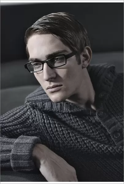 Young man wearing glasses sitting on a sofa