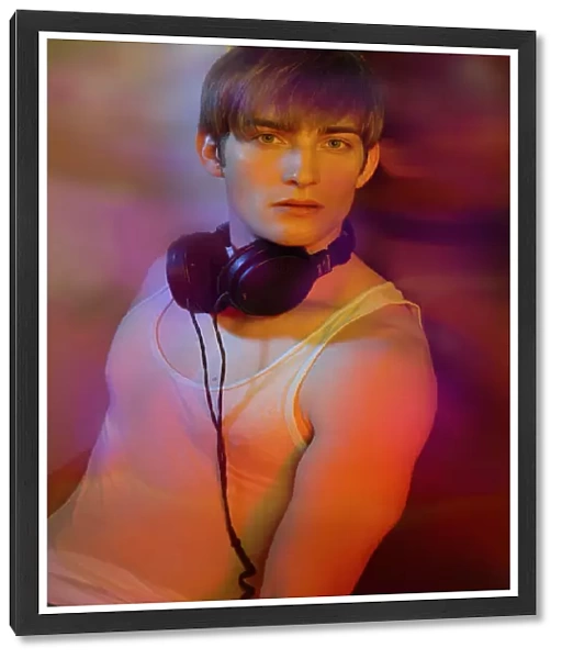 Young man in underwear with headphones in colorful lightYoung man in underwear with headphones in colorful light