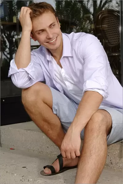 Young man wearing shorts, sitting
