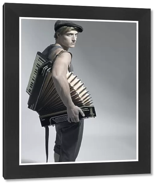 Man carrying an accordion, fashion shoot