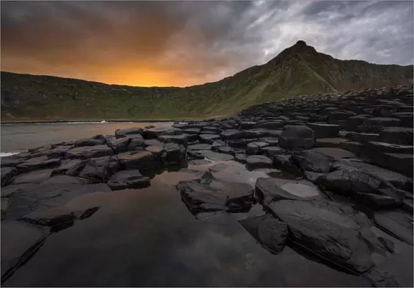 Giants Causeway with colorful sunrise looking towards the cliffs
