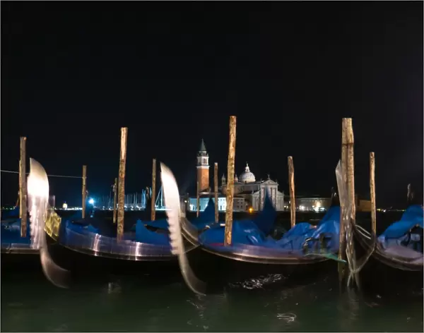 Gondolas moored by Saint Mark square with San Giorgio di Maggiore church in the background, Venice Italy