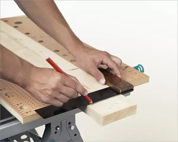 Person marking line on wood against square