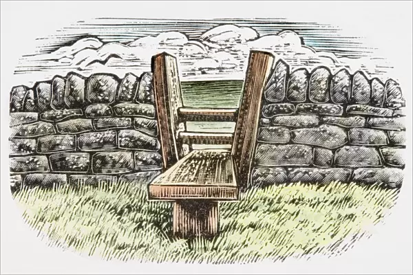 Wooden stile in stone wall enclosing a field