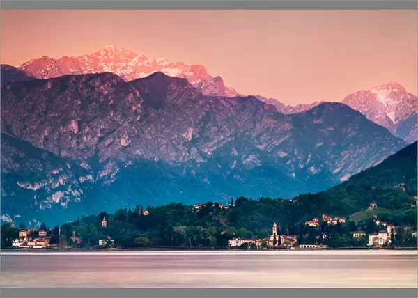 Afterglow. Sunset illuminates top of mountain overlooking village in Lake Como, Italy
