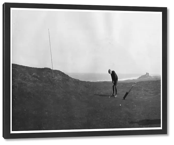 Golfers. April 1901: Two men play golf at Bamburgh Castle, Northumberland