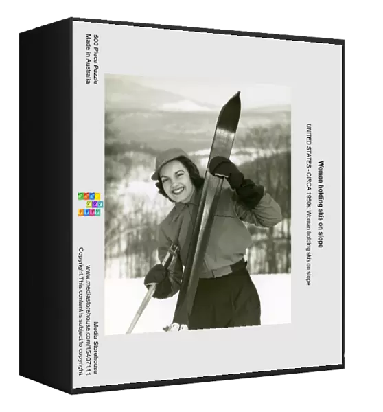 Woman holding skis on slope