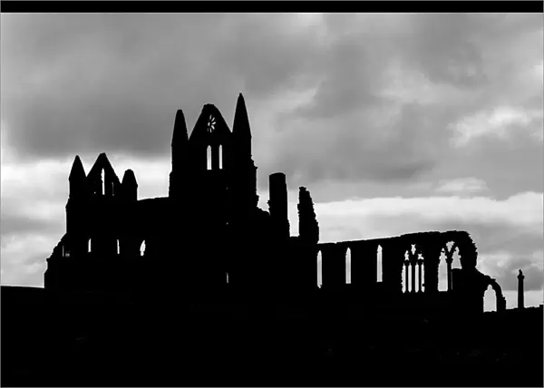 Whitby Abbey silhouetted against a cloudy sky, North Yorkshire, England