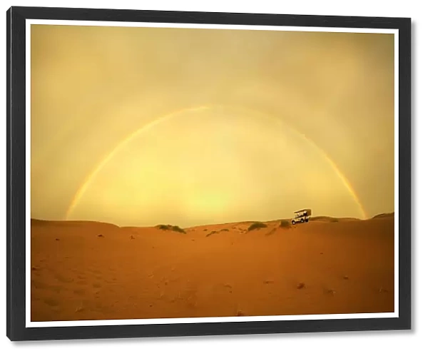 4X4 Vehicle on a Barren Desert Landscape Under a Rainbow
