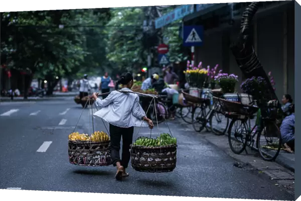A burden woman in Hanoi street, Vietnam