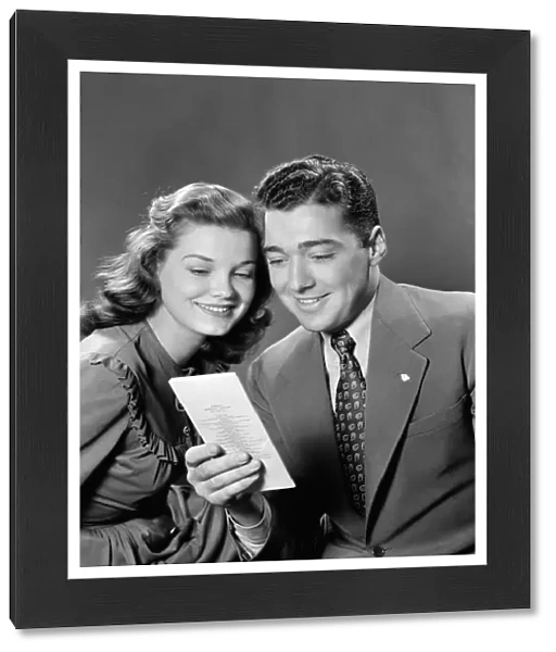 Smiling couple looking at insurance policy brochure