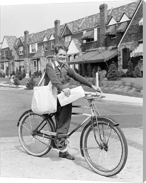 Paperboy on bicycle in suburban neighborhood, with sack over shoulder and folded newspaper in hand
